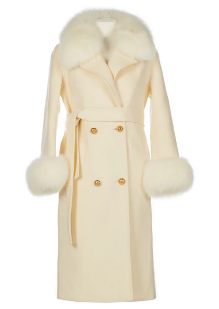 Ce manteau signature Cocowolfie issu d'un mélange en cachemire et laine ainsi que sa fourrure de renard est une silhouette classique inspirée d'une robe de chambre dans une teinte creme. Il fait rimer tailoring et confort par son toucher doux. Il est structuré par une ceinture ajustée à la taille et il est orné de boutons fantaisie dorés. 